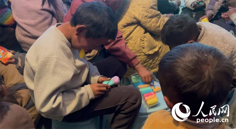 措果鄉(xiāng)塘仁村的孩子們正在用橡皮泥制作自己的情緒“小怪獸”。人民網(wǎng)記者 郝潔攝