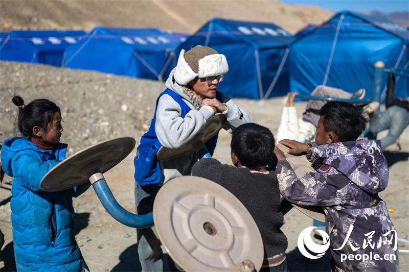 西藏星光社會工作服務(wù)中心社工久米旦增通過聊天談心，對孩子們進行災(zāi)后心理疏導(dǎo)。人民網(wǎng)記者 翁奇羽攝